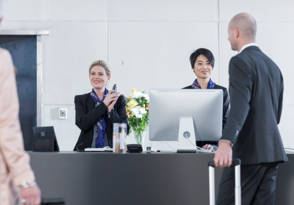 attentive-receptionists-helping-guests-at-hotel-check-in