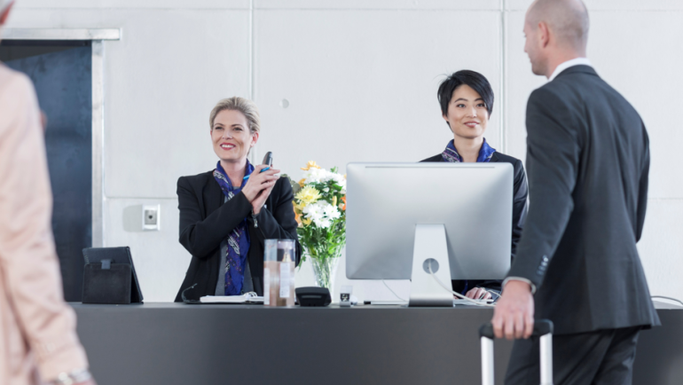 attentive-receptionists-helping-guests-at-hotel-check-in